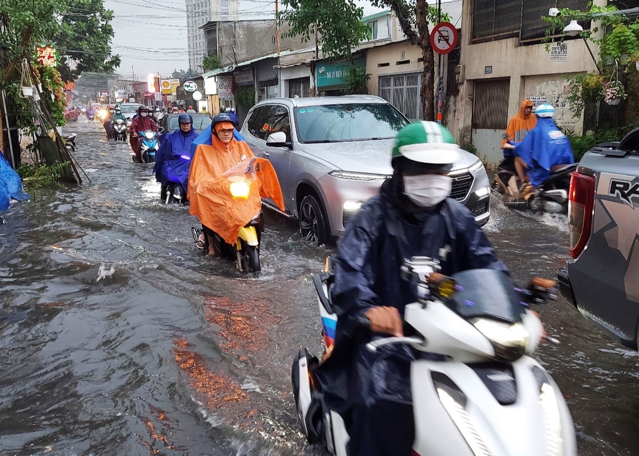 Người dân TPHCM lội biển nước mênh mông về nhà sau mưa lớn
