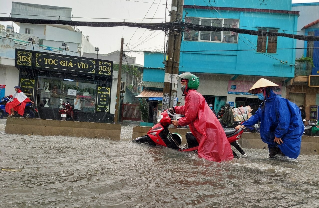 Người dân TPHCM lội biển nước mênh mông về nhà sau mưa lớn