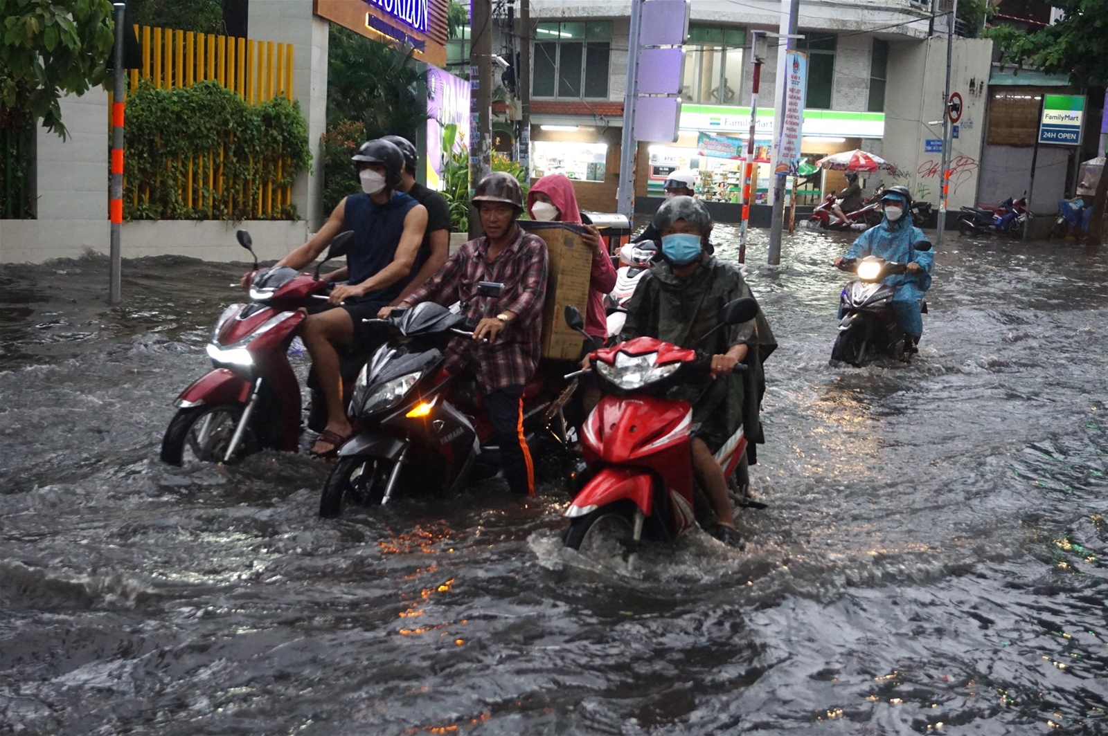 Người dân TPHCM lội biển nước mênh mông về nhà sau mưa lớn