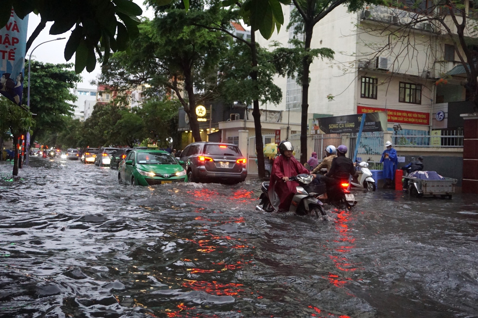 Người dân TPHCM lội biển nước mênh mông về nhà sau mưa lớn