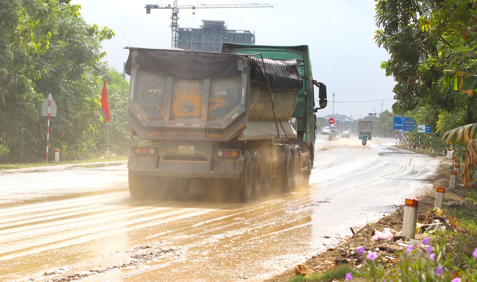 Đất đá từ xe tải rơi vãi khiến quốc lộ mưa nhầy nhụa, nắng bụi mù trời