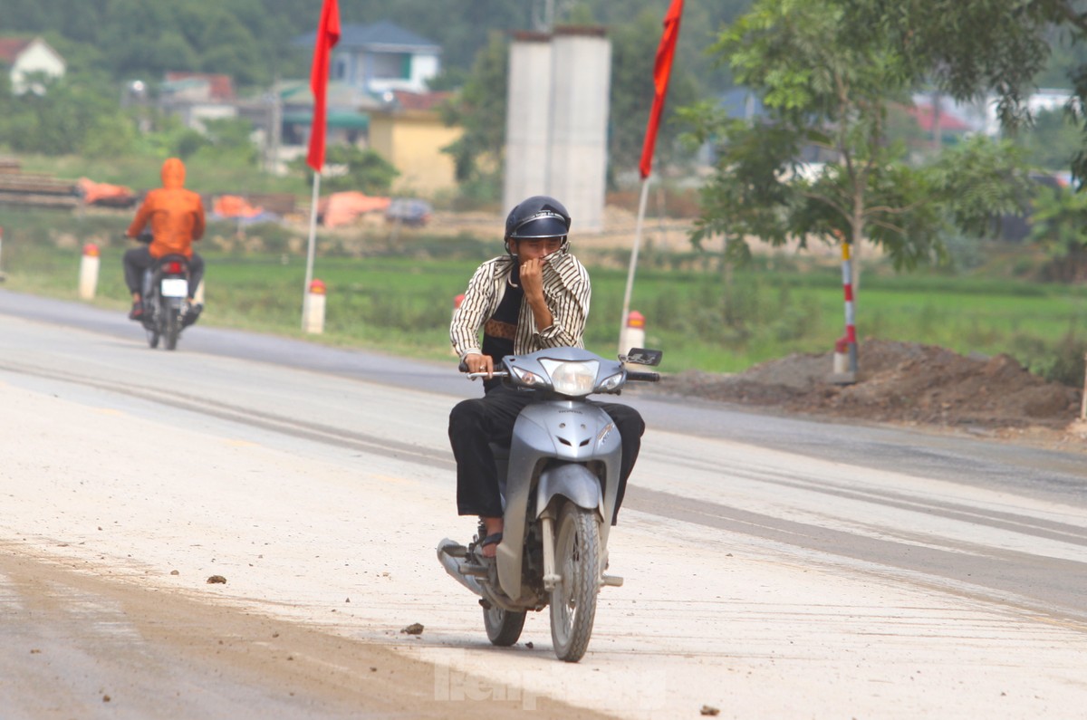 Đất đá từ xe tải rơi vãi khiến quốc lộ mưa nhầy nhụa, nắng bụi mù trời