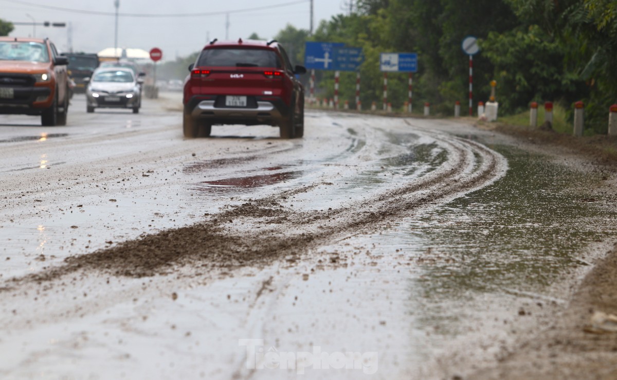 Đất đá từ xe tải rơi vãi khiến quốc lộ mưa nhầy nhụa, nắng bụi mù trời