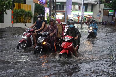 Người dân TPHCM lội biển nước mênh mông về nhà sau mưa lớn